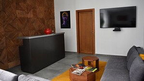 Una sala de estar moderna con un sofá, una mesa de centro, un televisor y una pared de acento de madera.