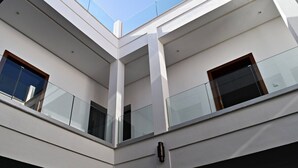 Un edificio de varios niveles con barandillas de vidrio y una vista despejada del cielo.