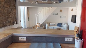 Une cuisine moderne avec un plan de travail en bois, des armoires rouges et un pare-feu en verre.