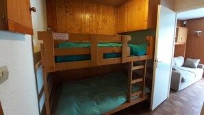 A bunk bed room with wooden walls and a white door. - East-facing studio cabin for 4 guests, pet-friendly (Valloire)