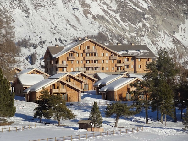 A large wooden lodge with multiple balconies and a mountain backdrop. - Duplex chalet 3 rooms, 6 pers, Superdevoluy station (Le Dévoluy)