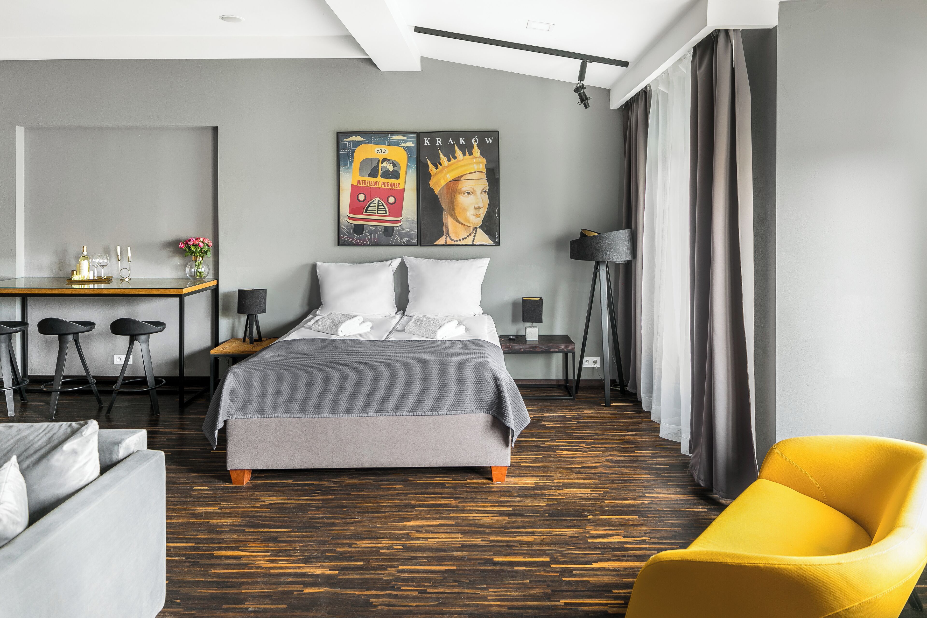 Una habitación de hotel moderna con una cama grande, un escritorio, una silla y un sofá.