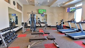 A gym with treadmills, dumbbells, and weight machines.