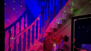 A staircase with a modern design, a vase with flowers, and a table with various items.