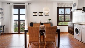 Una cucina con zona pranzo, una lavatrice e vista dalla finestra.