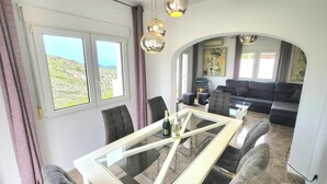 Un comedor con una mesa de vidrio, sillas y vistas al exterior.