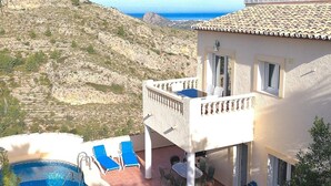 Une villa avec piscine, un espace salon extérieur et une vue sur les montagnes.