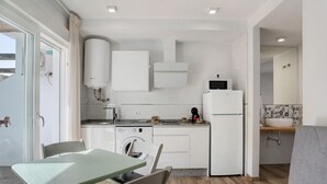 A compact kitchen with a dishwasher, microwave, and a sink with a faucet.