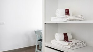 A white shelf with neatly folded white towels and a red tag.