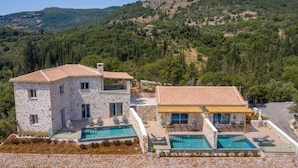 A two-story stone house with a swimming pool and outdoor seating area, surrounded by a mountainous landscape. - Spartia Suites - Brand New Seaview Suites - Spartia Suites - Brand New Seaview Suites (Zakynthos)