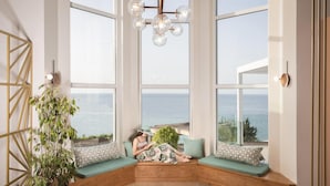 A room with large windows, a wooden bench, and a hanging light fixture. - Niki s Villa - Luxury Seaview Villa - Niki s Villa - Luxury Seaview Villa (Zakynthos)