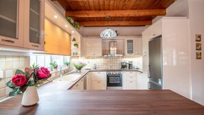 A modern kitchen with white cabinets, a wooden ceiling, and a central island. - Zante Sun I - Getaway Villa - Zante Sun I - Getaway Villa (Zakynthos)