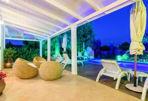 A covered outdoor area with lounge chairs and a pool. - Zante Sun I - Getaway Villa - Zante Sun I - Getaway Villa (Zakynthos)