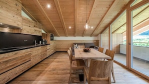A modern kitchen with wooden cabinetry and a dining area with a table and chairs.