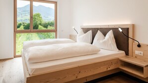 Ein Bett mit hölzernem Gestell, ein Nachttisch und eine Lampe.