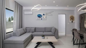 A modern living room with a grey sectional sofa, a wooden coffee table, and a dining area with a table and chairs.