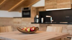 Une table en bois sur laquelle se trouve un saladier rempli de pommes, le tout dans un décor rustique.