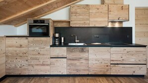 Une cuisine moderne avec des meubles en bois et un plan de travail noir.