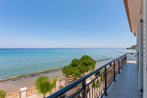 A balcony with a view of the sea, a sandy beach, and a distant shoreline. - Villa Elizabeth - Seafront Modern Villa - Villa Elizabeth - Seafront Classic Villa (Zakynthos)