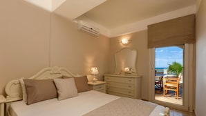 A bedroom with a bed, dresser, and a view of a balcony with outdoor furniture. - Villa Elizabeth - Seafront Modern Villa - Villa Elizabeth - Seafront Classic Villa (Zakynthos)