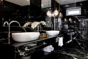 A modern bathroom with black marble walls, two sinks, a large mirror, and decorative lighting. - Maison Downtown Luxury Apartments - Maison Downtown Luxury Apartment (Zakynthos)