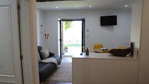 Ein modernes Wohnzimmer mit einer Couch, einem Couchtisch und einem Fernseher an der Wand.
