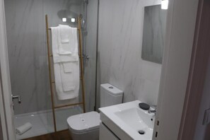 Ein Badezimmer mit einer Duschkabine, einer Toilette und einem Waschbecken.