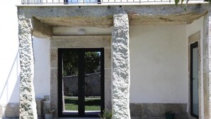 Ein Gebäudeeingang mit steinernen Bogen und Pflanzen in Kübeln.