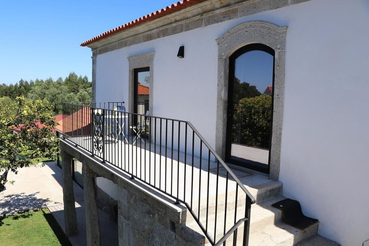 A building with a balcony, a door, and a window.