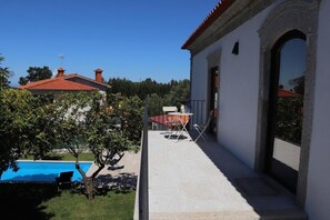 Ein Haus mit Pool, einer Terrasse mit Tisch und Stühlen und Blick auf die Umgebung.