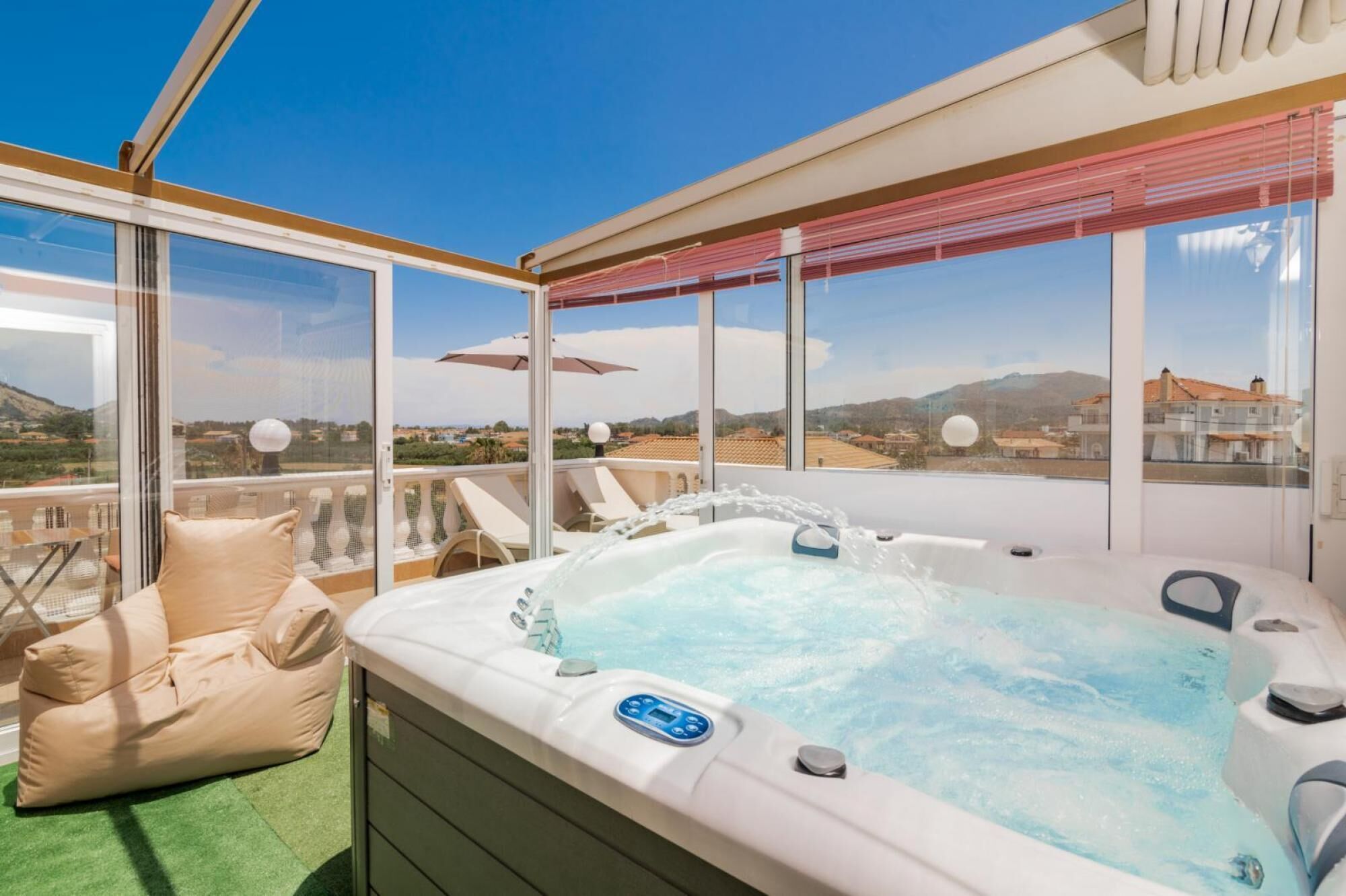 Un balcón con jacuzzi, sillones de descanso y vistas al paisaje.