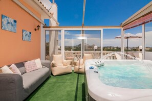 A balcony with a sofa, a hot tub, and a view of the landscape. - Matina s Family House With Your Private Jacuzzi - Matina s Family House With Your Private Jacuzzi (Zakynthos)