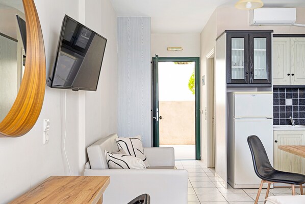 Een moderne keuken met een koelkast, kasten en een eethoek met een tafel en stoelen.