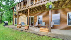 Una baita di legno con balcone, area salotto esterna e zona barbecue.