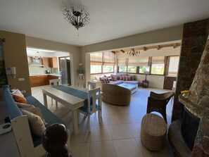 Un vaste espace de vie comprenant une table à manger, des canapés et une cheminée.