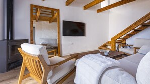 A modern interior with wooden beams, a fireplace, a TV, and a cozy seating area. - Country house 15 minutes from the beach (Málaga)