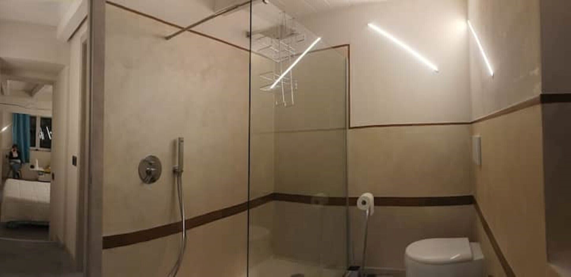 Une salle de bain moderne avec une douche à parois de verre, des toilettes et un porte-serviettes.