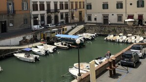 A marina with boats docked, surrounded by multi-story buildings with balconies and windows.