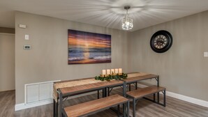 A dining area with a wooden table, benches, a chandelier, a wall clock, and a sunset painting. - ⭐️POOL|GAMEROOM*Lanai Hangout*Open Concept Design🌊 (Ocala)