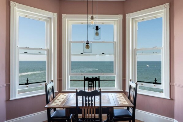 Enjoy meals with a view of the ocean from this dining area featuring a bay window and comfortable seating for four.