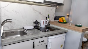Une cuisine moderne avec un dosseret en marbre, un lave-vaisselle encastré et un plan de travail en bois.