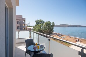 Ein Balkon mit Tisch, Stühlen und einem Glas Orangensaft.