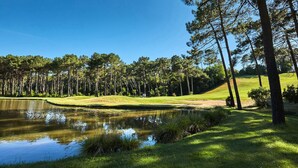 A golf course with a pond, trees, and a clear blue sky. - Swimming pool villa for 8 in Lacanau (Lacanau)