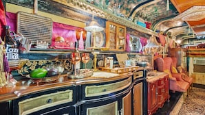 A vintage interior with wooden furniture, a patterned rug, and various decorative items.