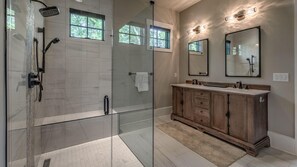 Een bad/douchecombinatie, een bubbelbad, een haardroger, handdoeken
