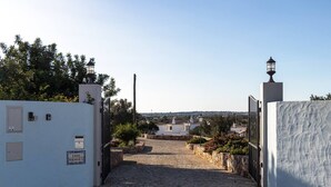 Ein Kopfsteinpflasterweg führt zu einem weißen Gebäude mit dem Schild 'CASA MOURISCADA'.