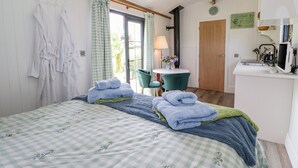 A bedroom with a bed, a desk with a computer, a chair, and a window with curtains. - High Rigg Shepherd's Sunrise (Brampton)