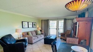 A living room with a sofa, two armchairs, a glass dining table, and a ceiling fan. - 1BR Destin Getaway | Beach Access + Golf Course (Destin)