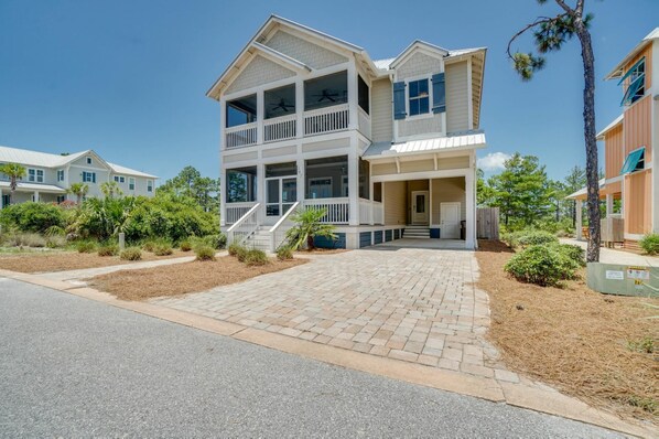 A two-story residential building with a covered porch and a staircase leading to the entrance.