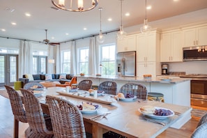 A spacious kitchen with white cabinets, a large island, and modern appliances.